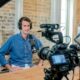 Making of eines Livestreams: ein Redner sitzt vor einer professionellen Kamera